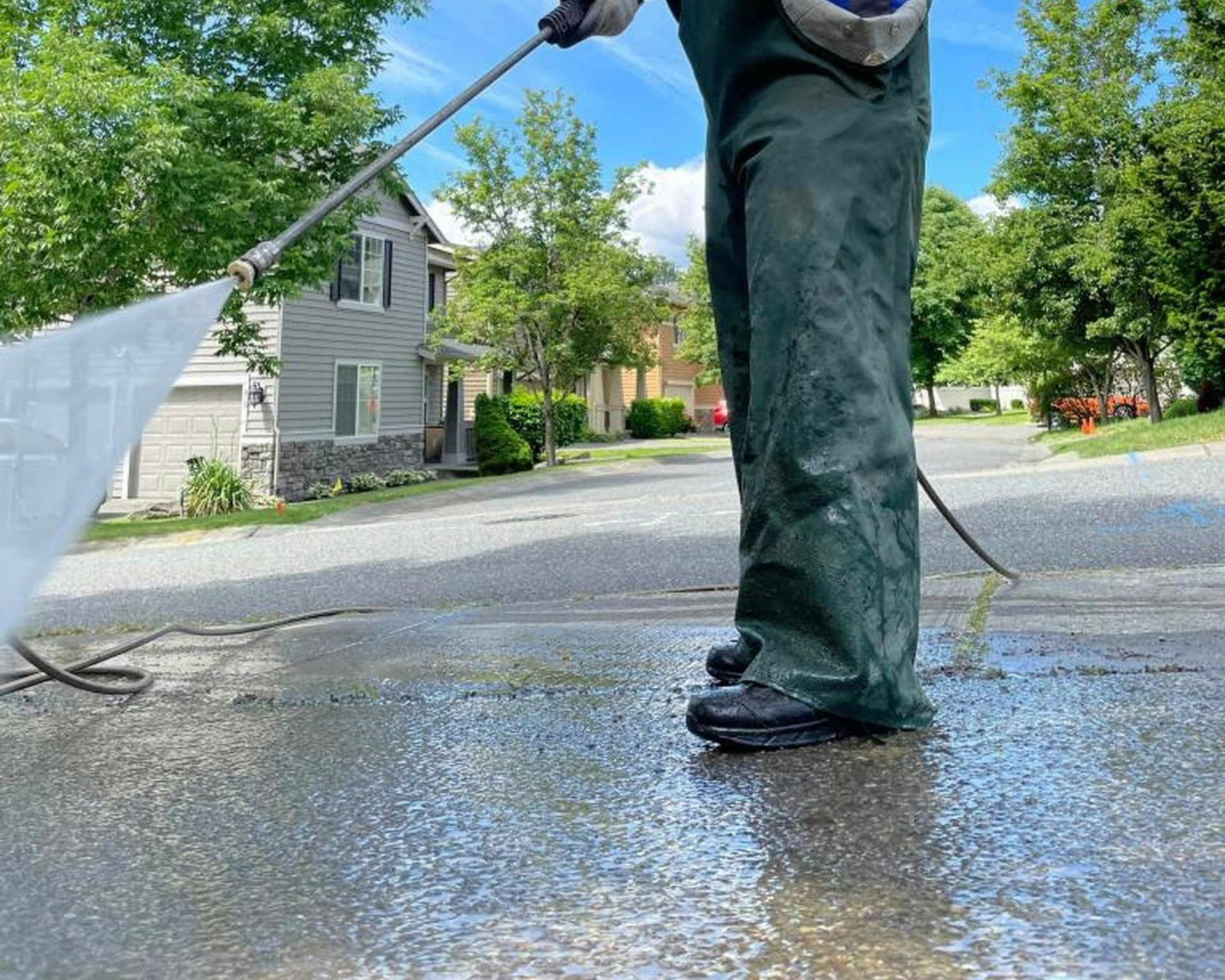 a man is cleaning the street with a hose